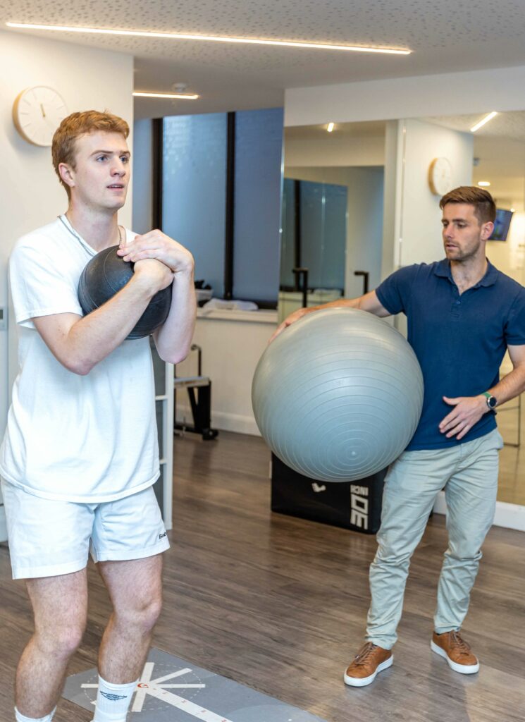 Men's Health Physio 3 Make patient completing rehab exercise with ball