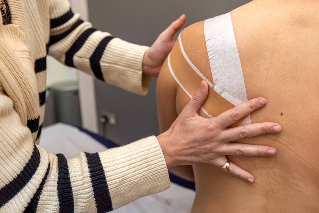 Physiotherapy 1 Physiotherapist applying tape to patient's shoulder