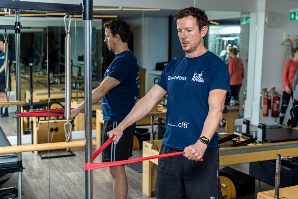 Photograph of man performing an exercise with a resistance band